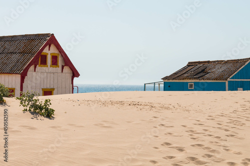 characteristic wooden house along the beach side at Costa da Caparica in Lisbon, Portugal. © Martina