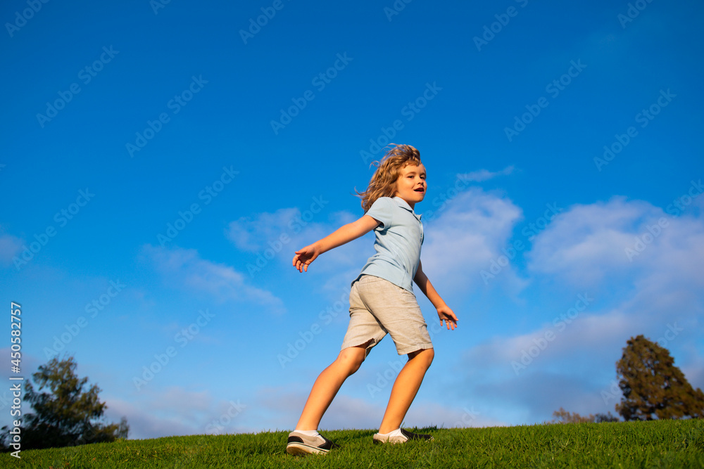 Kid running on grass field. Cute boy run in summer park. Child running on meadow. Kid running on grass field. Cute boy run in summer park. Child running on meadow.