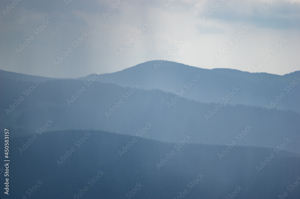 Carpathian mountains and forests in the haze on a summer day