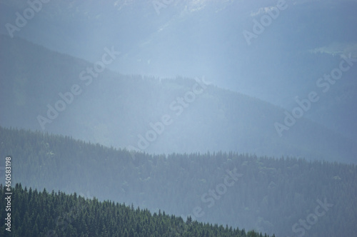 Sun rays and rain in the carpathian mountains in summer