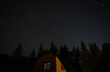 Beautiful night landscape, house among the forest against the background of the starry sky