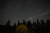 Beautiful night landscape, house among the forest against the background of the starry sky