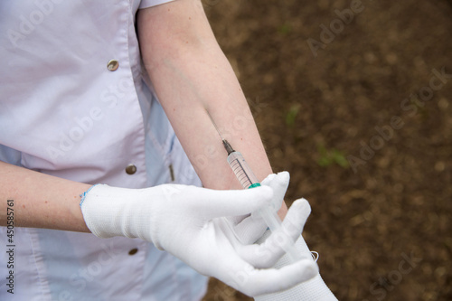 the girl is injecting herself with a vaccine from a syringe photo