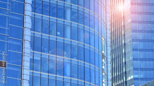 View of office building with glass wall under blue sky. Architecture details of business background.