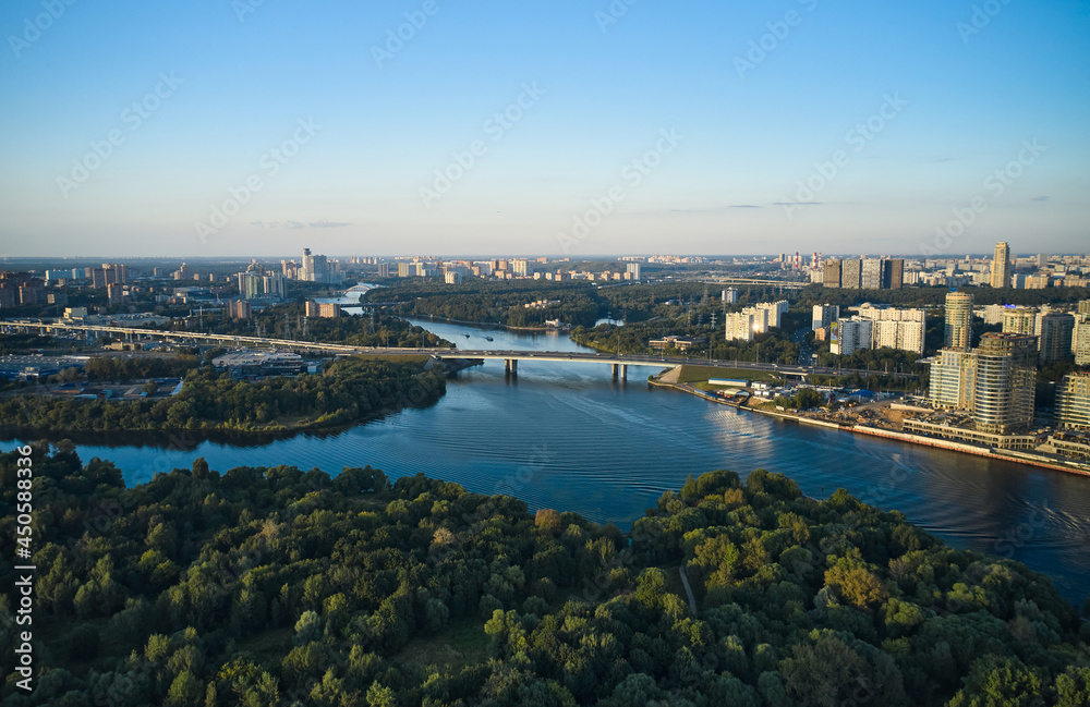 Aerial of cityscape with a river and forest