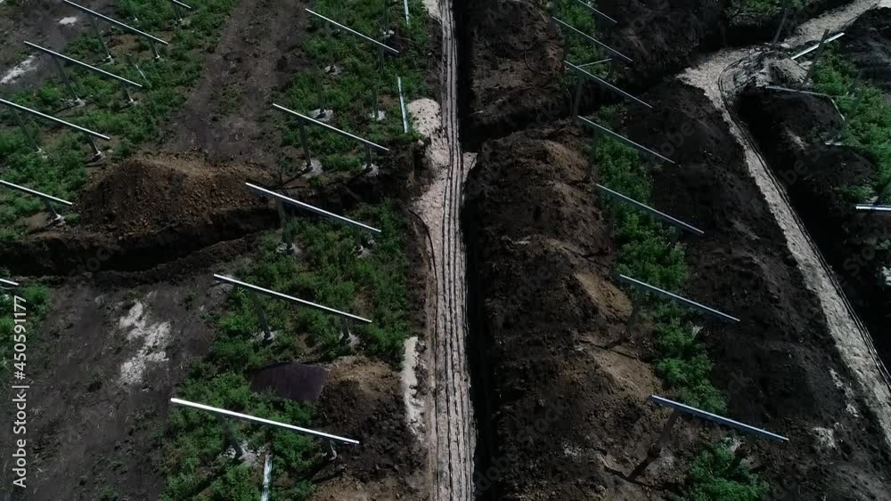 Construction site of a solar power station in the field, trench for the cables Construction site of a solar power station in the field, trench for the cables