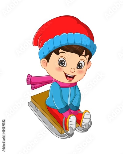 Cute little boy sledding down a hill