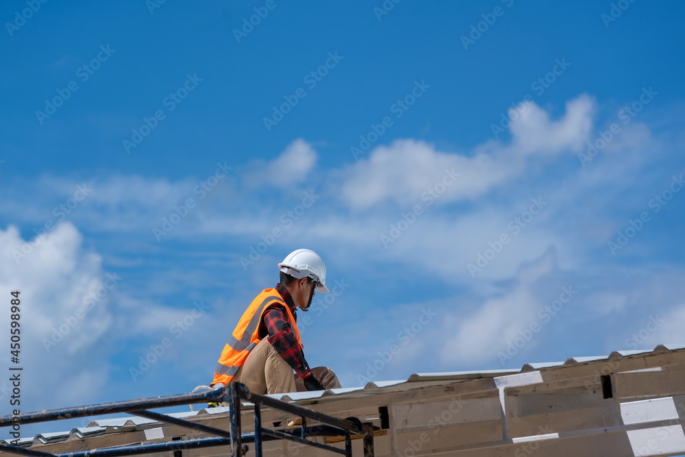 Roofing,Construction workers wearing safety harness checking and installation assembly of new roof,Roofing tools. Roofing,Construction workers wearing safety harness checking and installation assembly of new roof,Roofing tools.