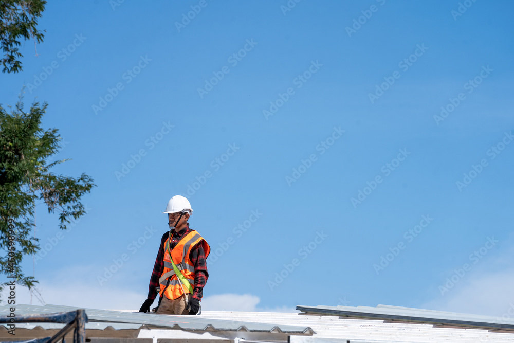 Roofing,Construction workers wearing safety harness checking and installation assembly of new roof,Roofing tools. Roofing,Construction workers wearing safety harness checking and installation assembly of new roof,Roofing tools.
