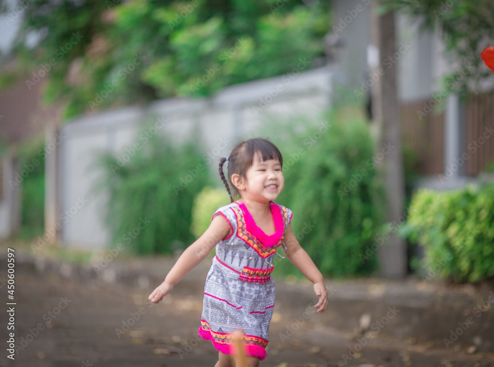 Naklejka premium close-up background view of an asian girl Running around and carrying parasols during school holidays, there was a blur of fun movements during the day with parents.