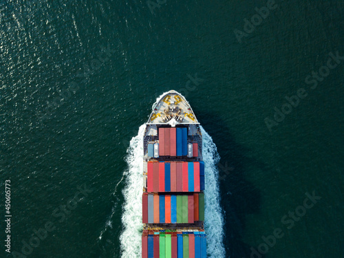 Aerial top view from drone, Cargo vessel sail to the sea with peaceful wave. Professional business logistics and transportation of cargo ship.