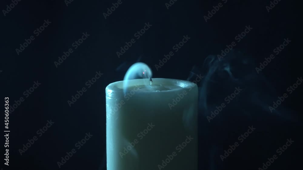 Velón en fondo negro, apagándose y dejando humo