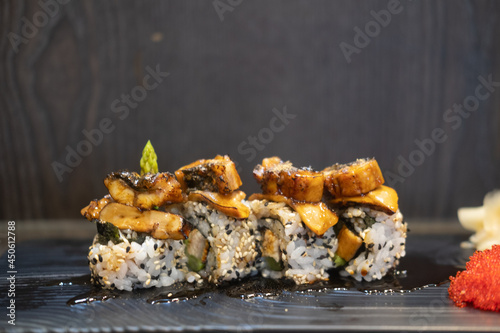 Sushi roll white and black sesame seeds and eel on top