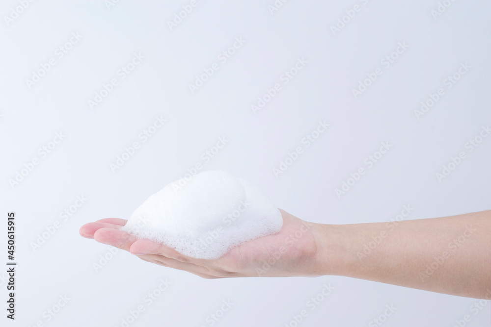 white soapy foam bubbles texture on hand. cleaning and wash essence facial cleanser background concept white soapy foam bubbles texture on hand. cleaning and wash essence facial cleanser background concept