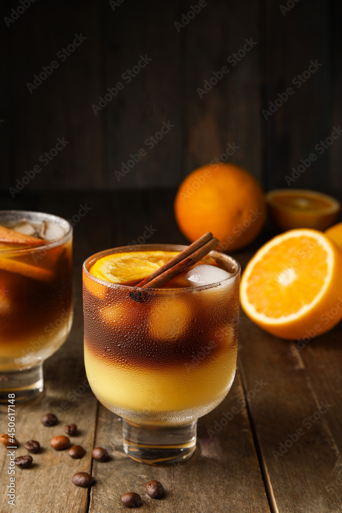 Glasses of tasty coffee with orange juice on wooden background