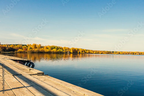 Fototapeta Naklejka Na Ścianę i Meble -  Natural autumn landscape. Old pier on lake with machine tires.