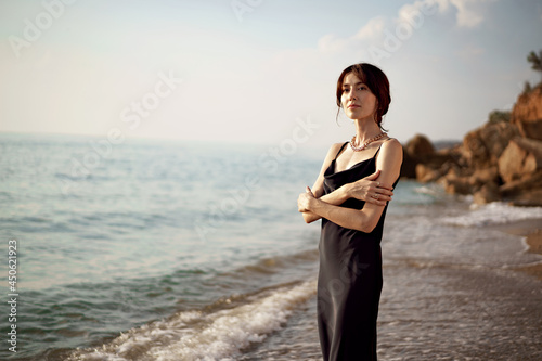 Fototapeta Naklejka Na Ścianę i Meble -  Happy woman on the beach walking by seaside