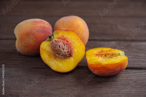 Ripe juicy peaches lie on a wooden table.