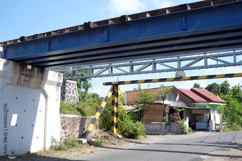 Klaten, Indonesia, Aug 11, 2021. The structure of an iron rail bridge crossing over an asphalt road.