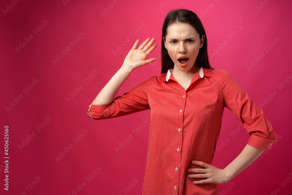 Young woman's reaction on what she heard, surprise, on pink background Young woman's reaction on what she heard, surprise, on pink background