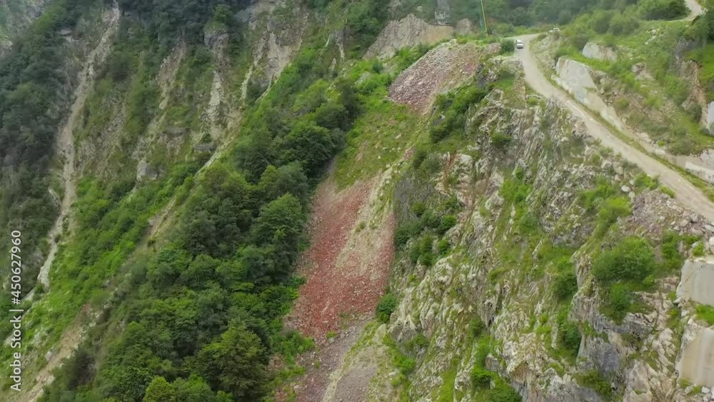 Aerial view. Mountain road in a narrow gorge of steep rocks. Mountain road serpentine. A cliff next to a mountain road Aerial view. Mountain road in a narrow gorge of steep rocks. Mountain road serpentine. A cliff next to a mountain road