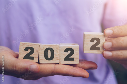 Hand hold wooden cubes 2022 background, copy space. Goal concept, action plan, strategy, new year.