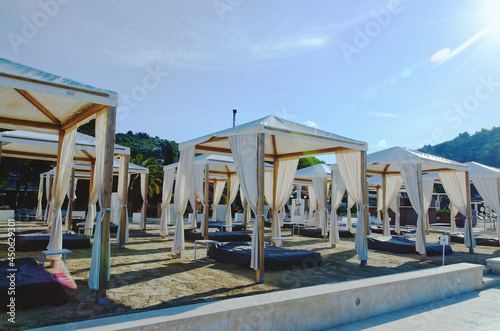 Landscape outdoor cabana bed on the sand beach in sunny day. Adriatic coast and sea in Slovenia. Holiday, wedding and celebration concept.  © Oleksandra