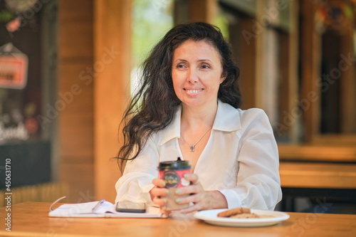 Cheerful elegant elderly woman smiling. Head shot close up portrait happy healthy middle aged woman sitting in a cafe, and is waiting for a friend
