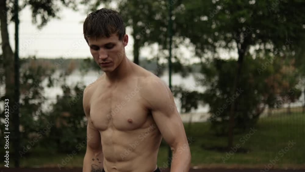 A muscular guy is playing basketball while training at the sports ground A muscular guy is playing basketball while training at the sports ground