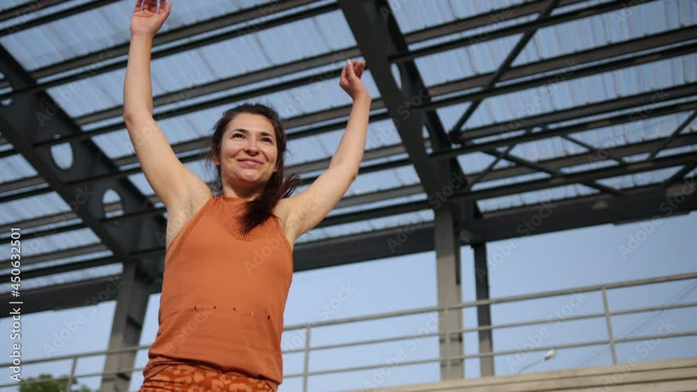 woman who does stretch outdoor. Does warm-up stretching of her body. Confident woman who does stretch outdoor. Does warm-up stretching of her body. Confident