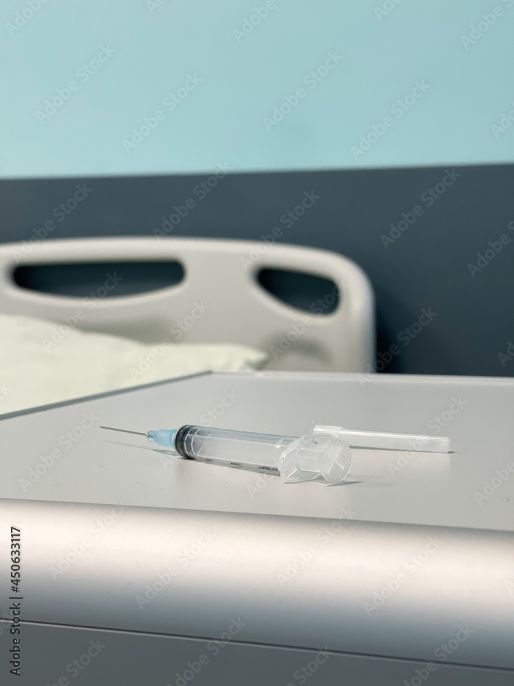The syringe is on the bedside table in the hospital room