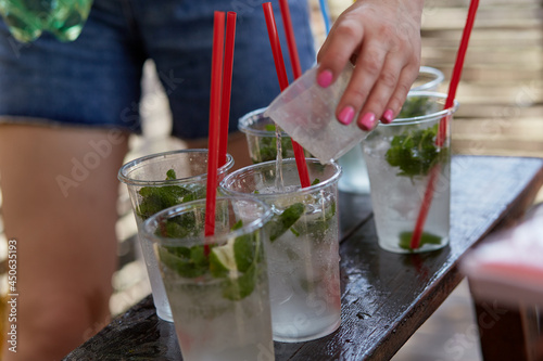 Young woman at a bachelorette party makes a mojito cocktail for the company. Preparation instructions. Step 2