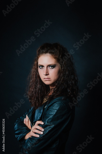 Portrait of sexy young woman posing in black jacket and jeans