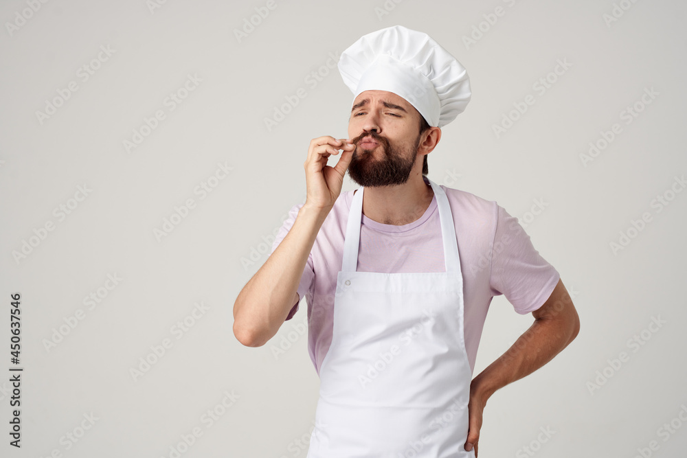 Cheerful male chef in a white apron gestures with his hands restaurant kitchen to professionals Cheerful male chef in a white apron gestures with his hands restaurant kitchen to professionals