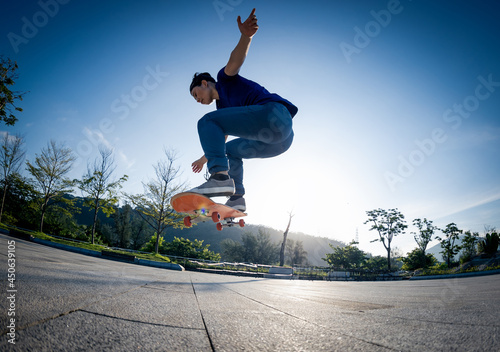 Asian woman skateboarder skateboarding in sunrise city