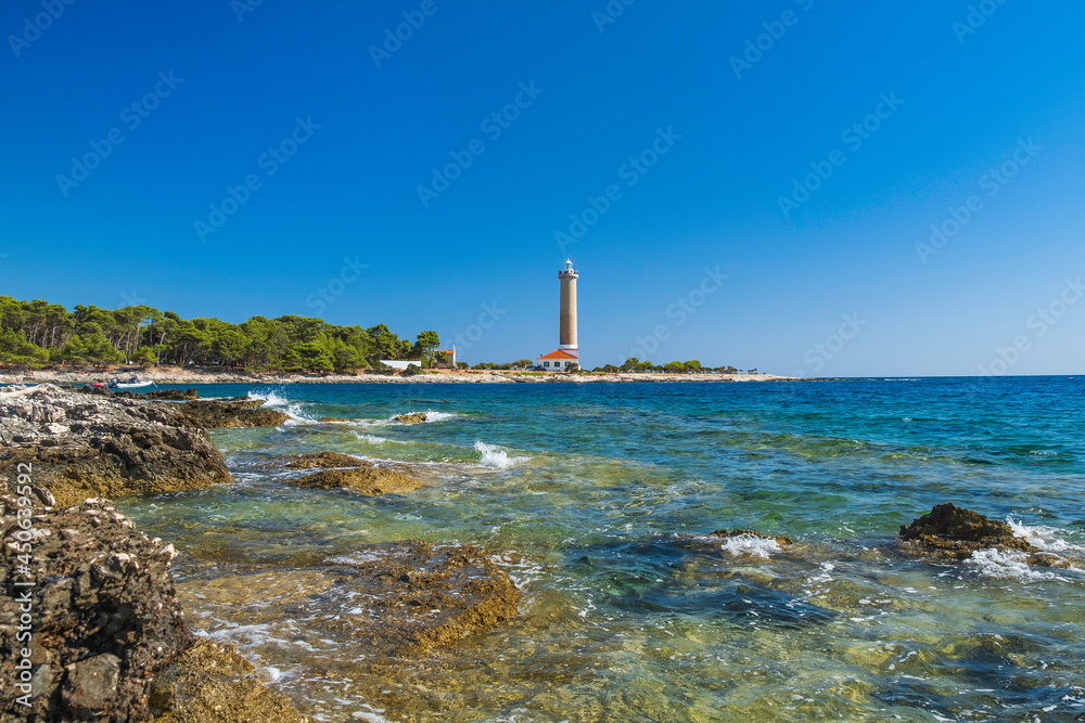 Lighthouse of Veli Rat on the island of Dugi Otok, Croatia, beautiful seascape and rocks in foreground