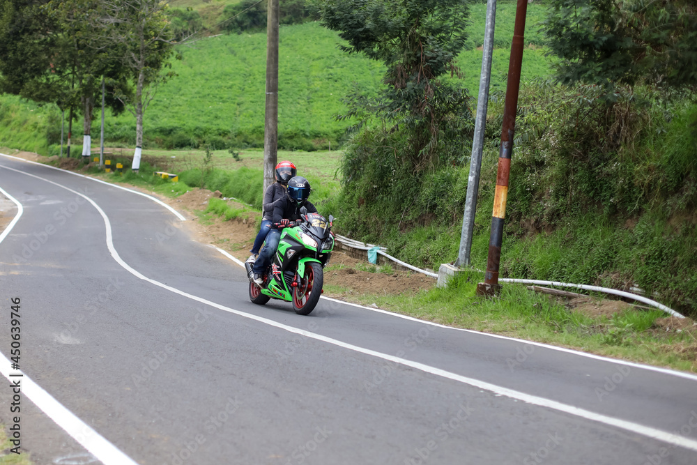 sport motorbike rider crossing on winding road