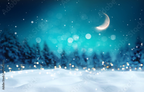 Beautiful winter background for Merry Christmas and Happy New Year with fluffy snowdrifts against background of night winter forest, falling snow and magical sky with moon. © Laura Pashkevich