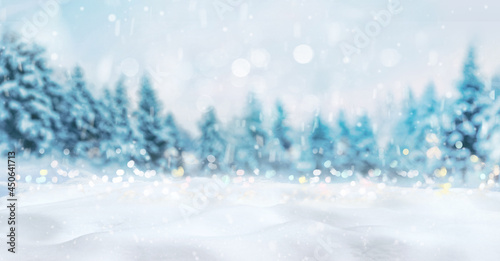Beautiful winter natural background of snow and blurred forest, Gently falling snow flakes and christmas lights against blue morning sky, free space for your decoration.  Wide format. © Laura Pashkevich