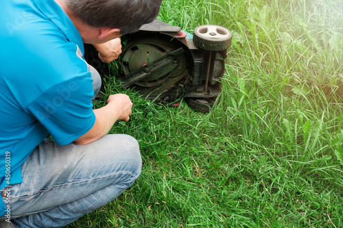 Quadro em tela Broken lawn mower on lush green grass