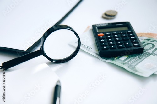 Calculator, paper money, a stack of coins and a folder with documents isolated on white background. Family budget concept and investing. Close up