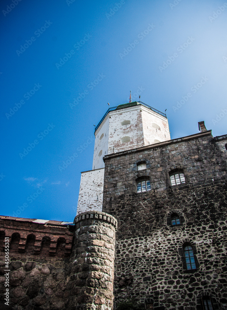old fortress made of bricks of white color against a background of blue sky close-up 