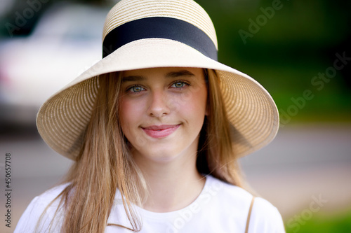 portrait of a 12-year-old girl in a hat on the background of the road © Julie Boro