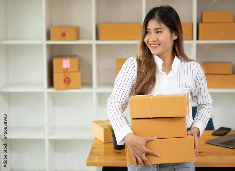 Startup small business entrepreneur SME, young asian woman working with laptop computer and delivery packaging box, online market packing, SME e-commerce seller concept. Startup small business entrepreneur SME, young asian woman working with laptop computer and delivery packaging box, online market packing, SME e-commerce seller concept.