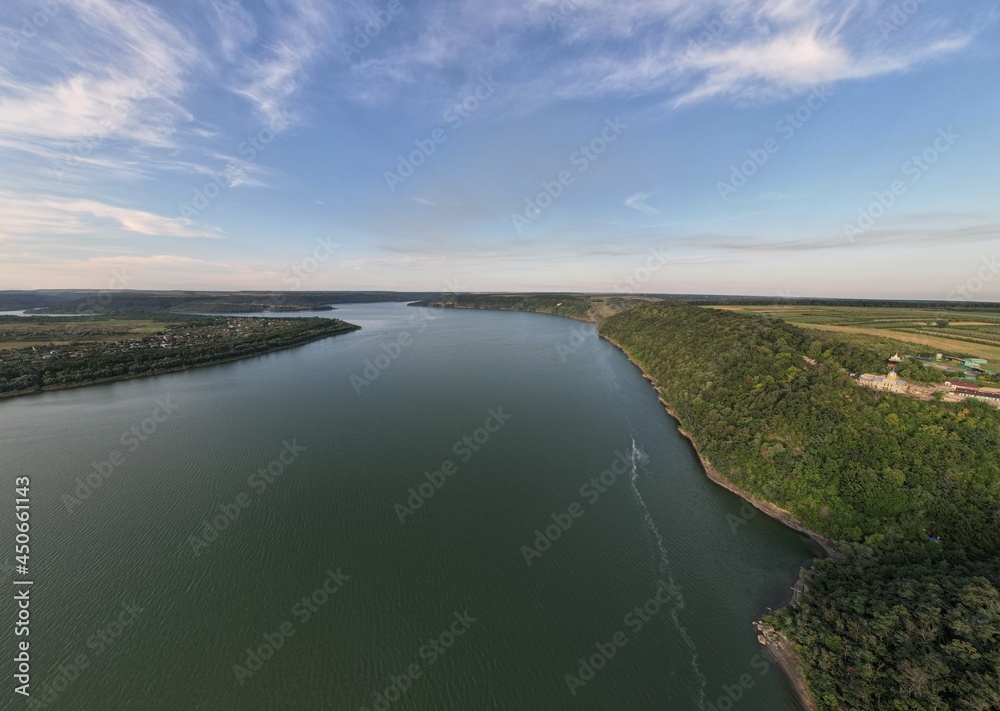 Landscape aerial view of the huge river Dnister with the tall trees around. Panoramic view.