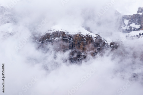 Close view of mountain landscape in snowy winter with fog and low clouds, Pyrenees, national park, Spain.
