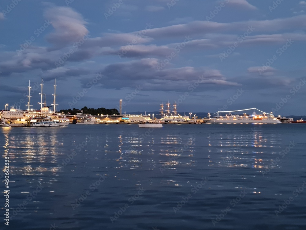 Scenic view of port at night. Beautiful twilight pastel colors background in Split, Croatia. Sail boats and yachts in the evening harbor of Adriatic Sea.