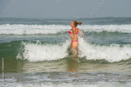 beautiful young woman having fun in the waves