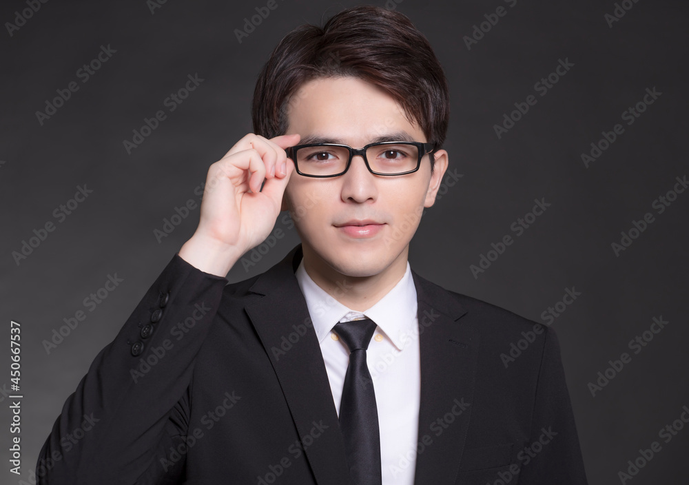 Young buisnessman in black suit and wearing eyeglasses