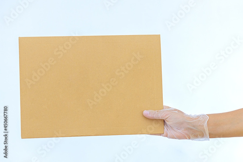 A woman's hand in medical gloves holds a paper envelope Amazon on white background. Express delivery. The courier brought the package . Online order. Home delivery  © Olga